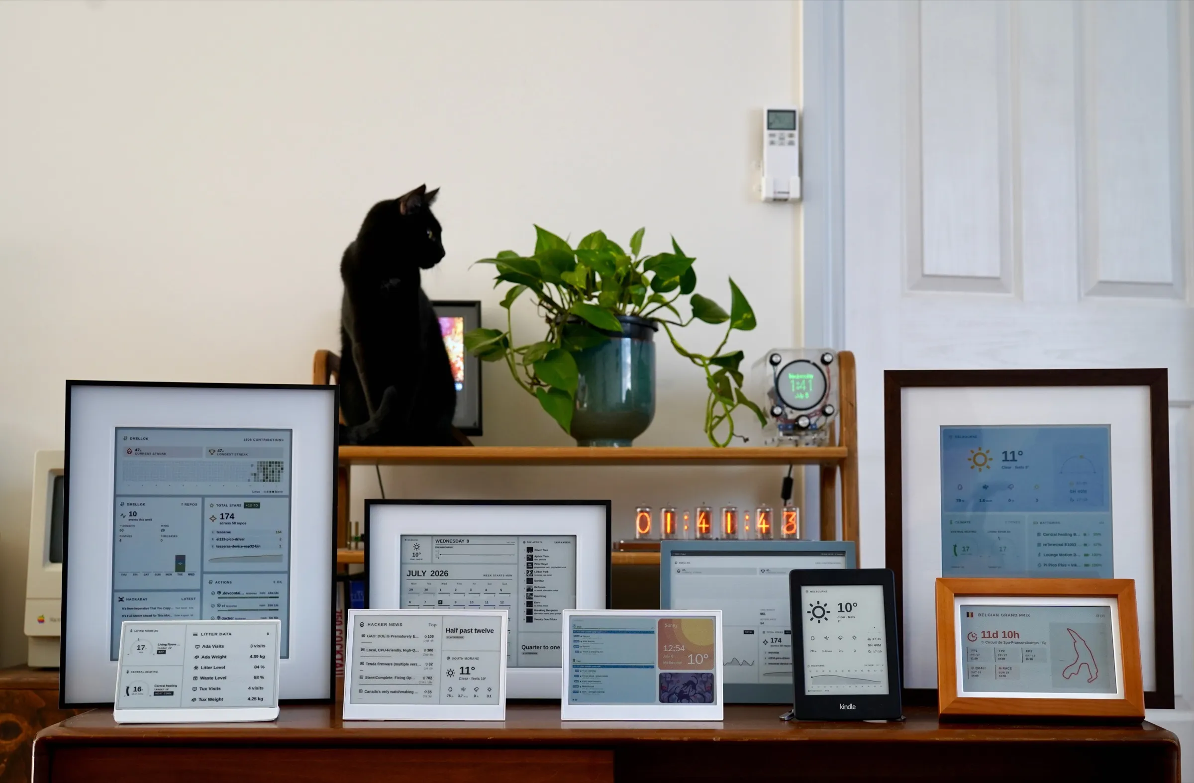 A dresser lined with framed e-paper panels showing weather, now-playing, F1 and calendar dashboards